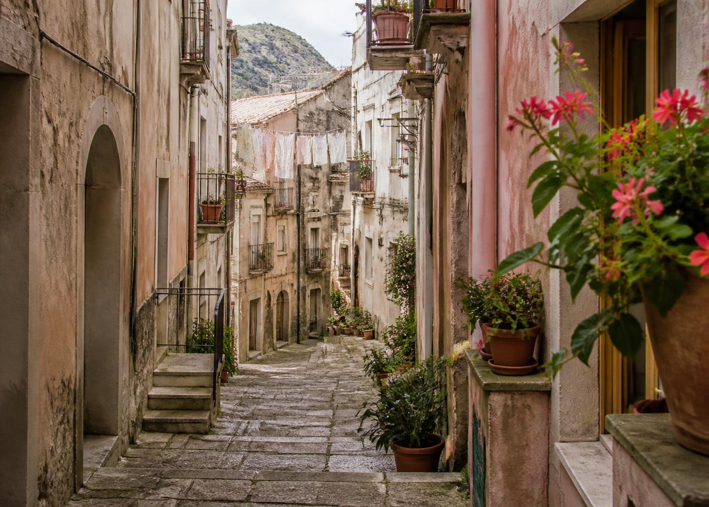 Stepped village street in southern Italy with plaster houses and potted plants